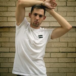 Fashionable man in casual wear posing confidently against a brick wall in Chicago.